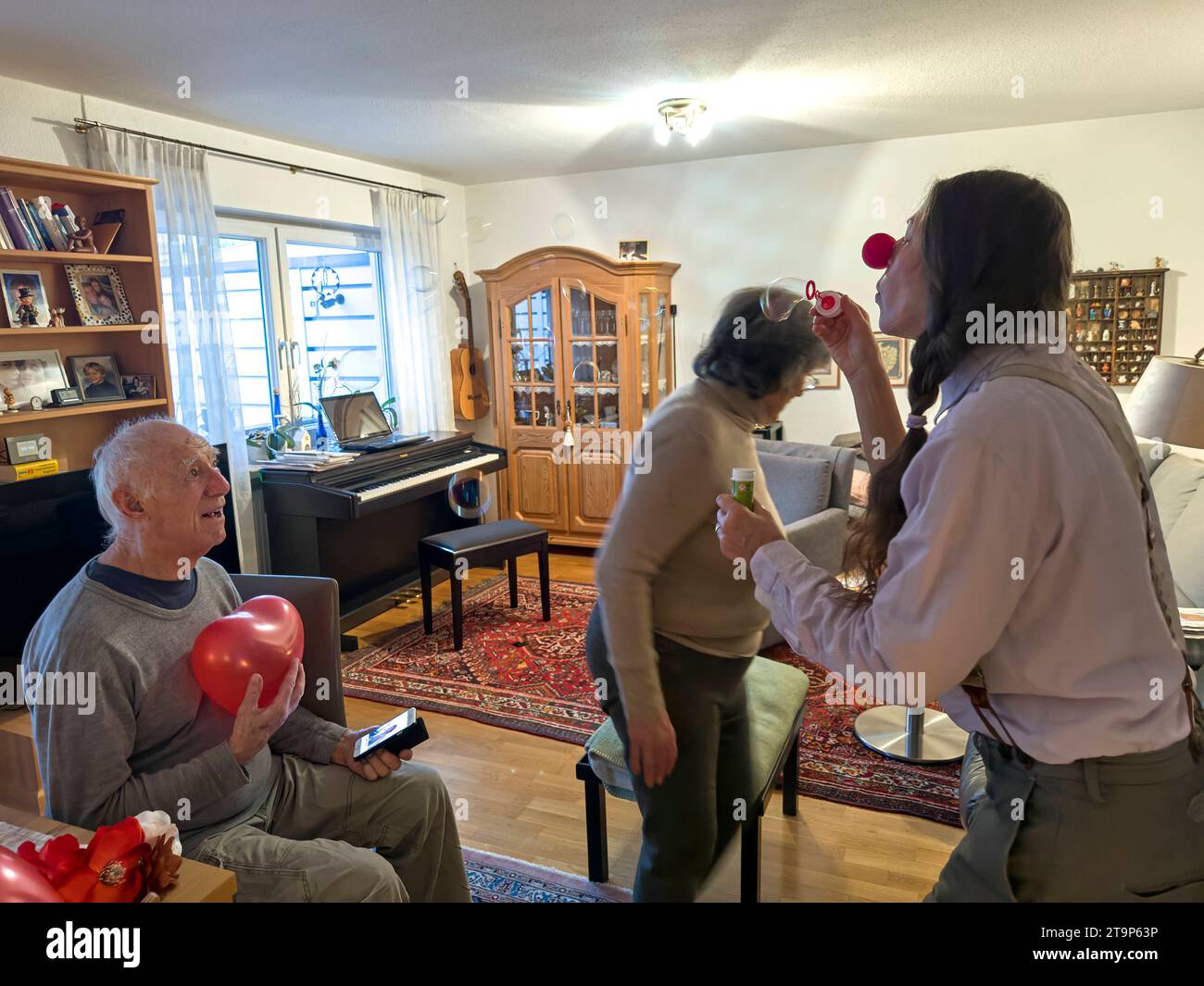 Un couple de personnes âgées rit d'un clown féminin le 24 novembre 2023 à Biessenhofen, Bavière, Allemagne. Modèle libéré crédit : Imago/Alamy Live News Banque D'Images
