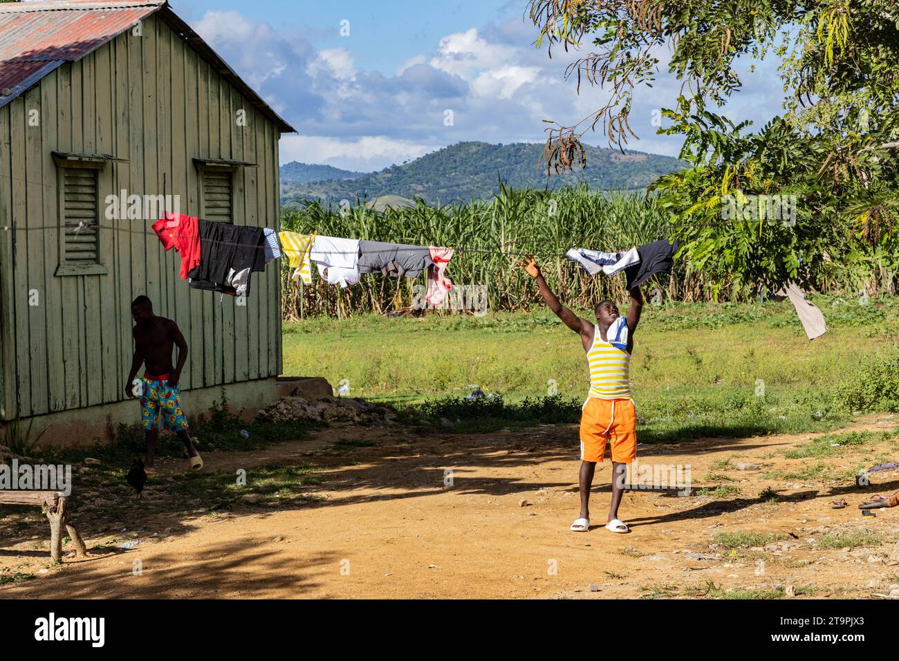 El Seibo, République dominicaine. 21 novembre 2023. Un homme attrape des vêtements sur une corde à linge dans une batey, ou communauté, à El Seibo, en République dominicaine, le 21 novembre 2023. La plupart des résidents de ces communautés sont soit des immigrants haïtiens sans papiers, soit des Dominicains dénationalisés d'origine haïtienne. Les États-Unis ont empêché Central Romana Corporation, Ltd. D'importer du sucre dans le pays le 23 novembre 2022 après que des allégations de travail forcé aient été portées contre la société. (Photo de Carlos Berríos Polanco/Sipa USA) crédit : SIPA USA/Alamy Live News Banque D'Images