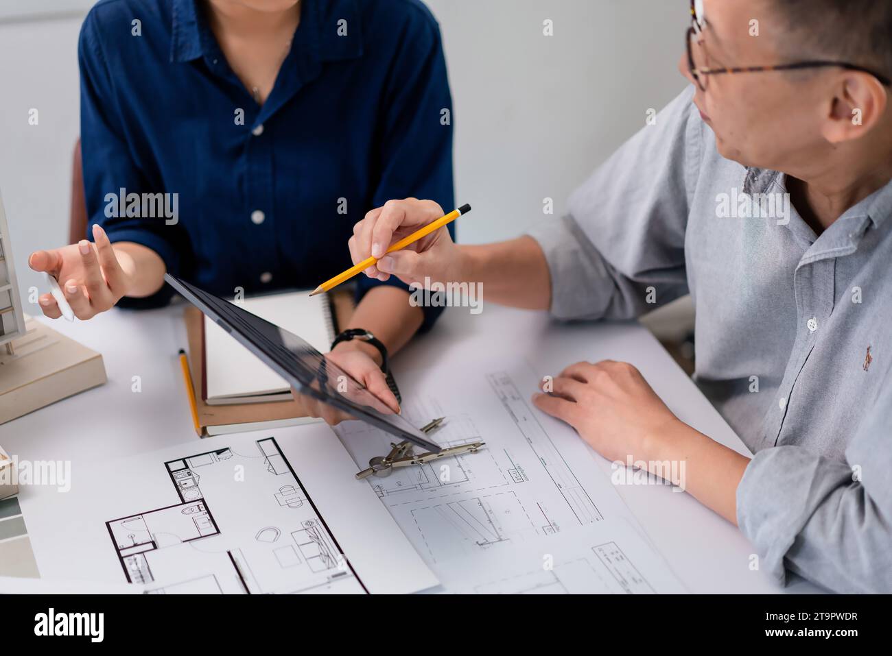 Deux architectes vérifiant le plan sur la tablette et analysant la construction du projet de construction. Banque D'Images