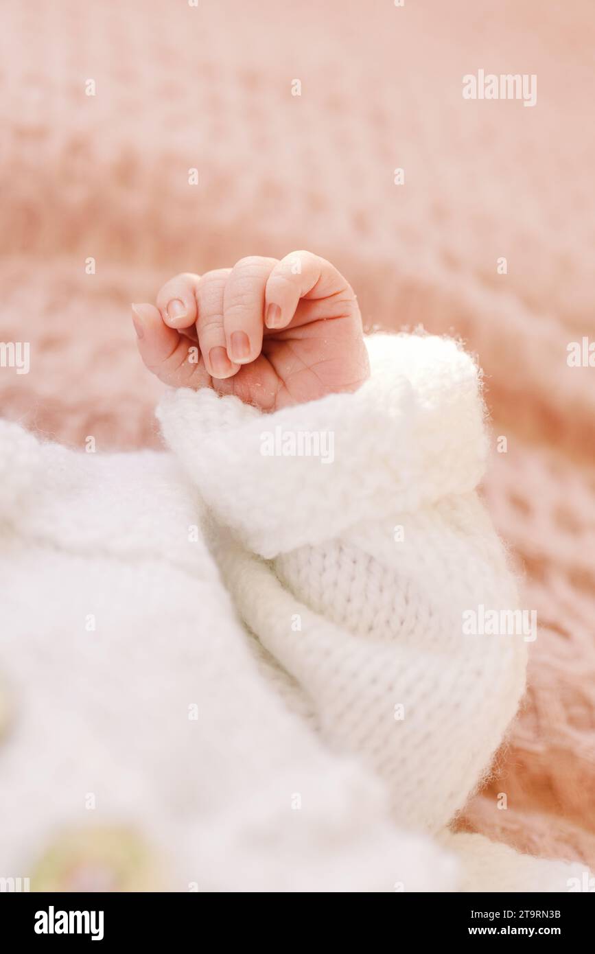 Gros plan de la main minuscule bébé fille nouveau-né sur la couverture rose Banque D'Images