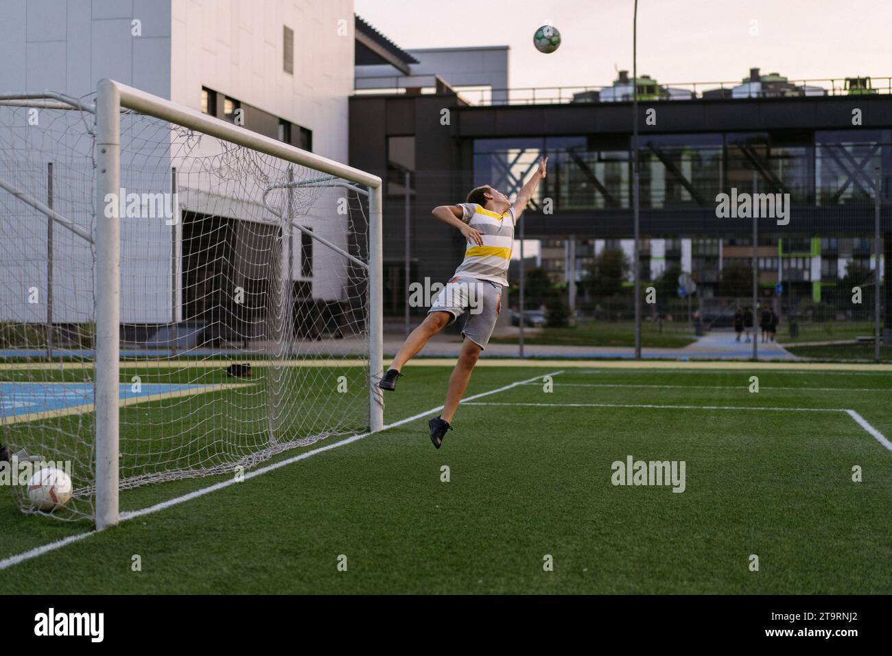 Enfants jouant au football, gardien de but garçon attrape balle dans le but. Banque D'Images