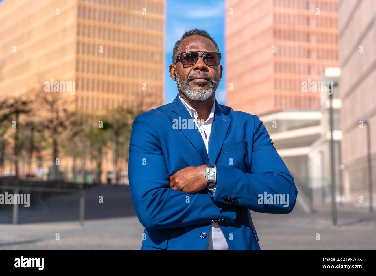 Portrait d'un fier homme d'affaires africain debout avec les bras croisés à l'extérieur Banque D'Images
