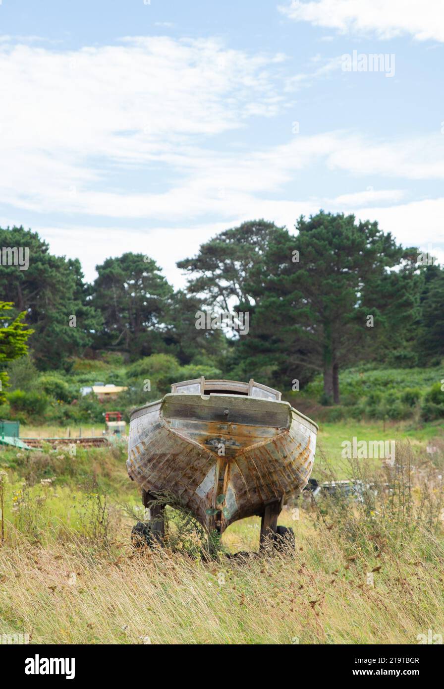 un bateau en bois cassé dans l'herbe, concept de temps Banque D'Images