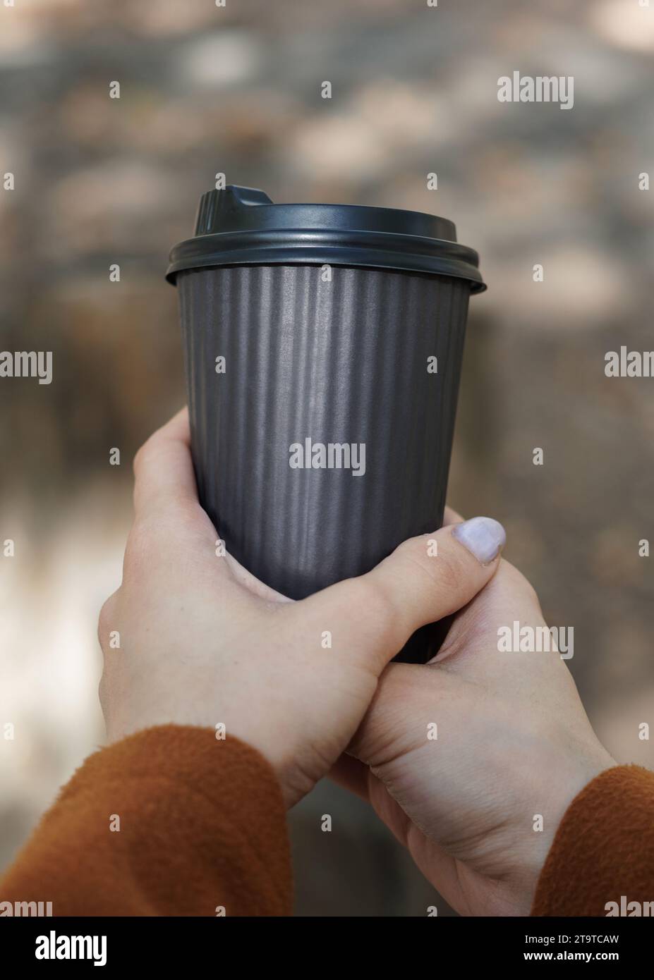 Femme tenant une tasse de café en papier à emporter en main. Banque D'Images