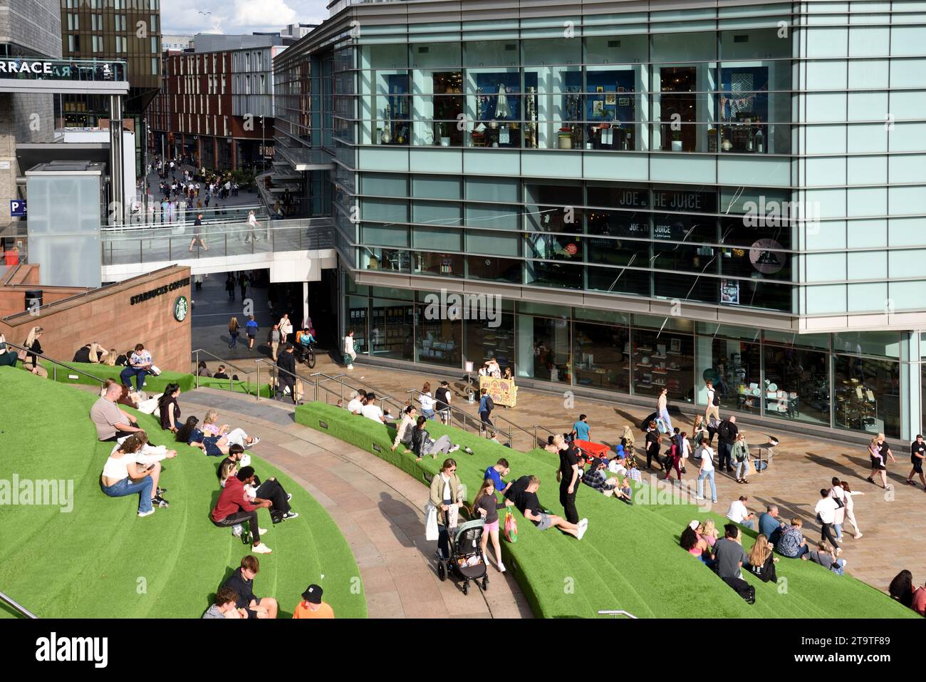 Les clients siègent sur des terrasses de gazon artificiel dans le centre commercial Liverpool One City Centre et le bâtiment moderne John Lewis Liverpool Angleterre Royaume-Uni Banque D'Images