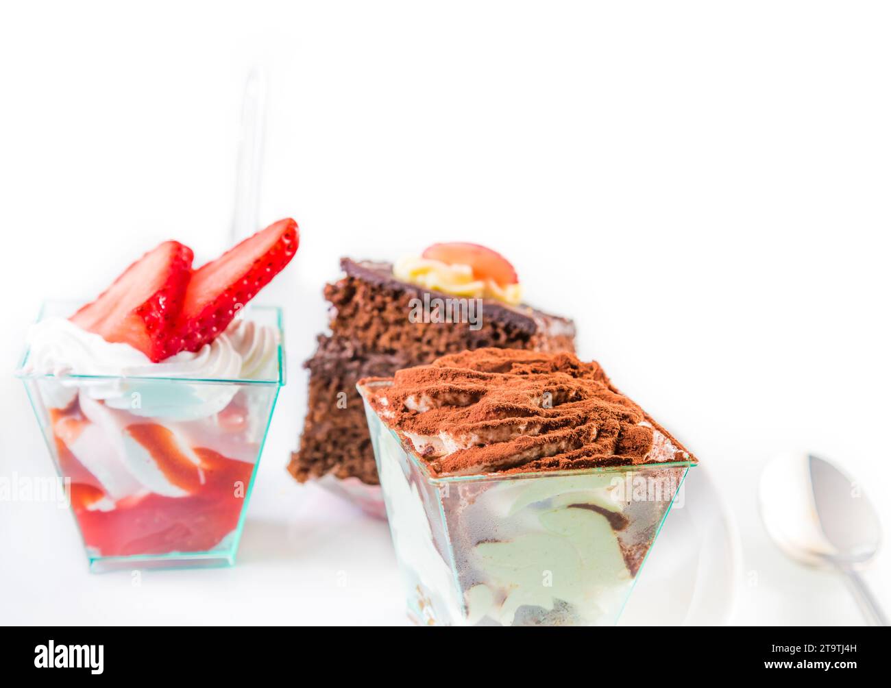 délicieuse tranche de gâteau au chocolat nommé tiramisu sur blanc près de petits gâteaux Banque D'Images