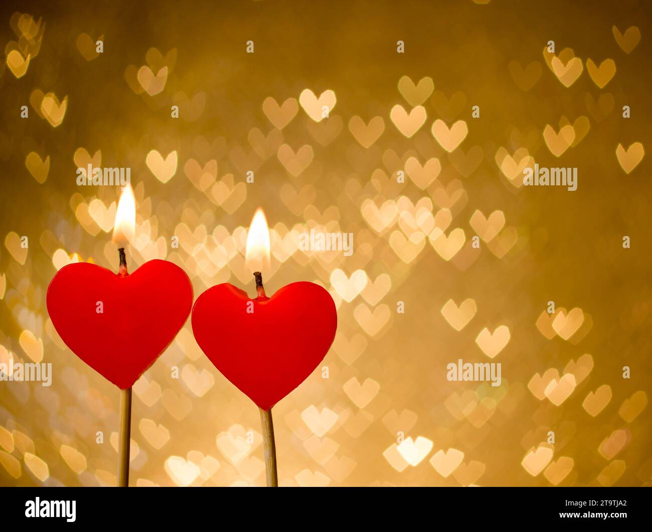 bougies de coeurs rouges sur des coeurs dorés bokeh comme fond, saint valentin et concept d'amour Banque D'Images