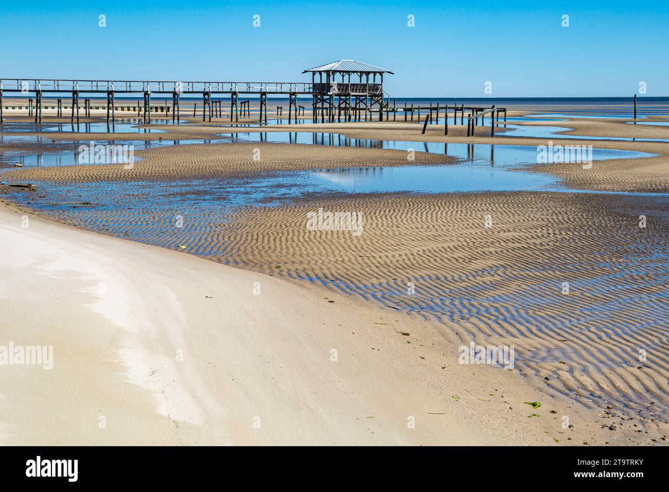Vieux quai en bois délabré, hangar à bateaux, et jetée se dresse au-dessus des piscines de marée sur la plage de Waveland, Mississippi à marée basse. Banque D'Images