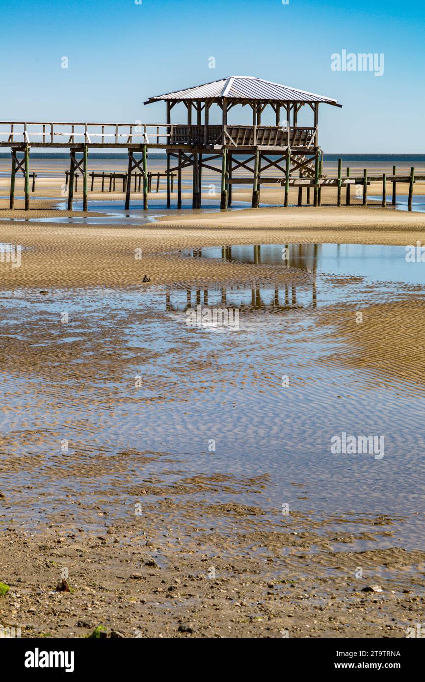 Vieux quai en bois délabré, hangar à bateaux, et jetée se dresse au-dessus des piscines de marée sur la plage de Waveland, Mississippi à marée basse. Banque D'Images