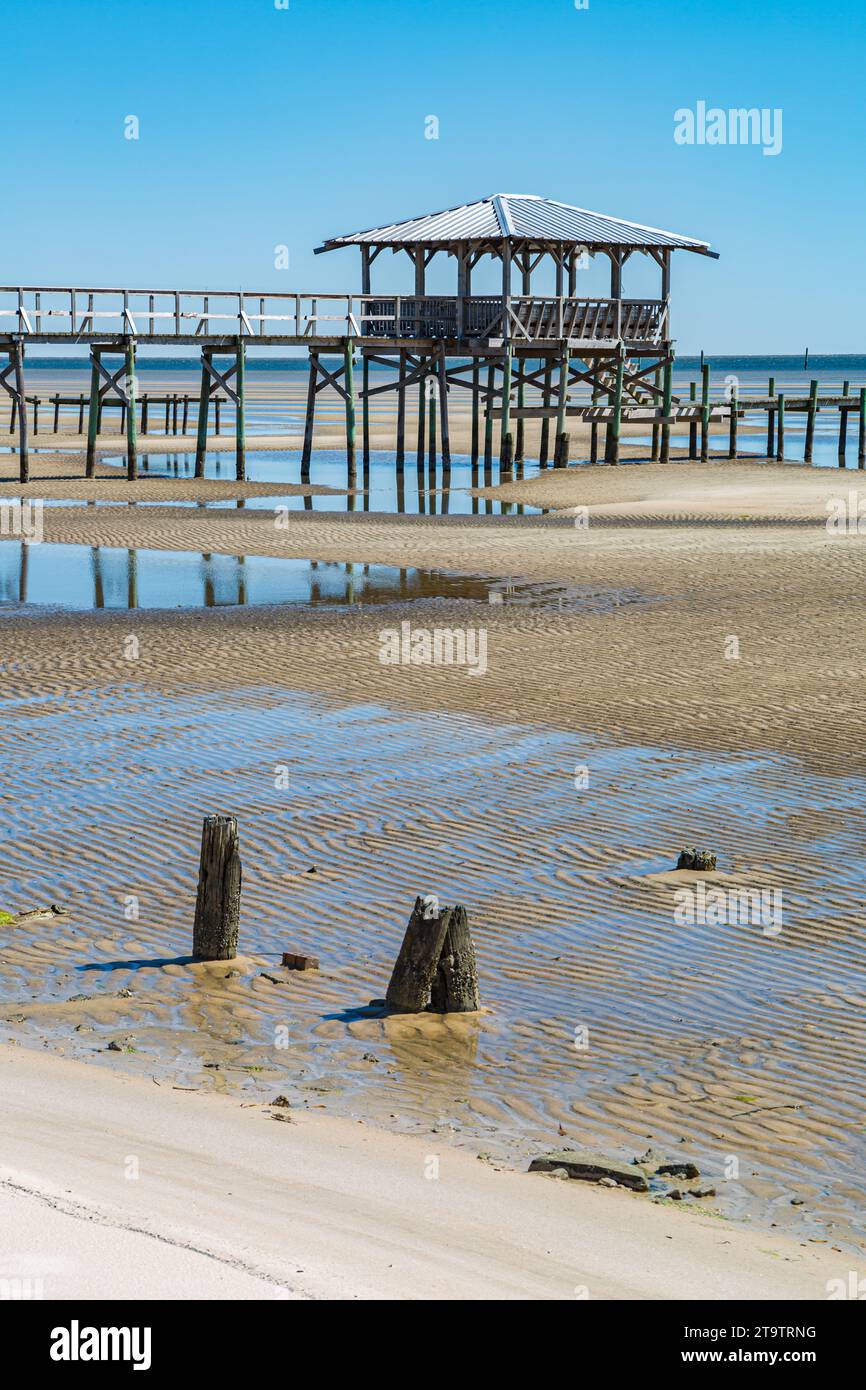Vieux quai en bois délabré, hangar à bateaux, et jetée se dresse au-dessus des piscines de marée sur la plage de Waveland, Mississippi à marée basse. Banque D'Images