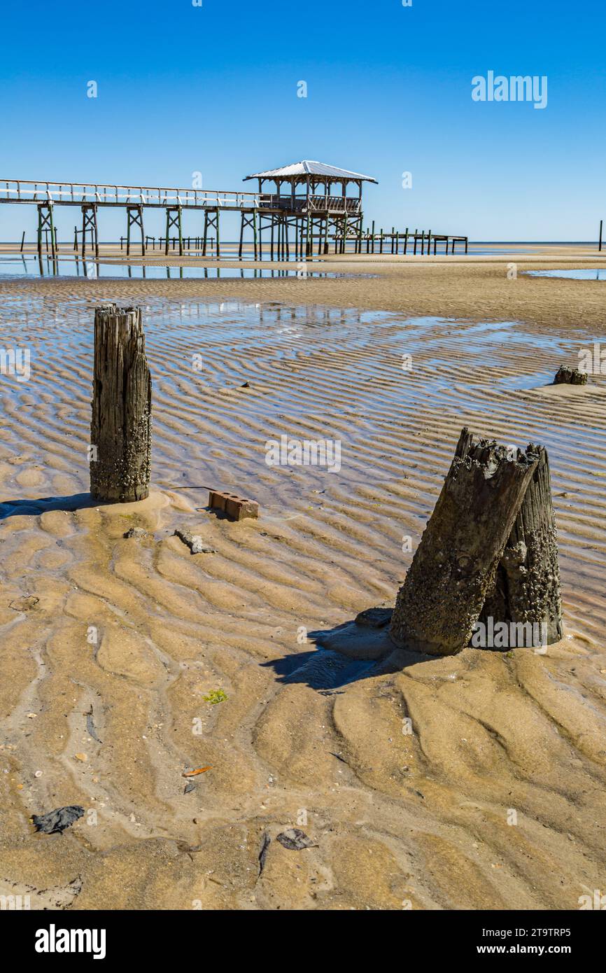 Vieux quai en bois délabré, hangar à bateaux, et jetée se dresse au-dessus des piscines de marée sur la plage de Waveland, Mississippi à marée basse. Banque D'Images