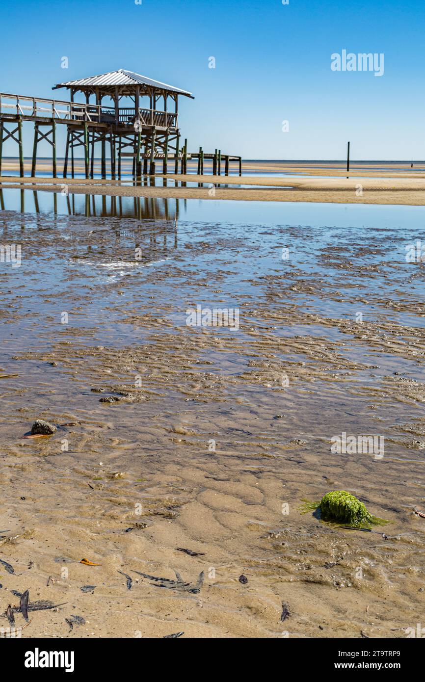 Vieux quai en bois délabré, hangar à bateaux, et jetée se dresse au-dessus des piscines de marée sur la plage de Waveland, Mississippi à marée basse. Banque D'Images