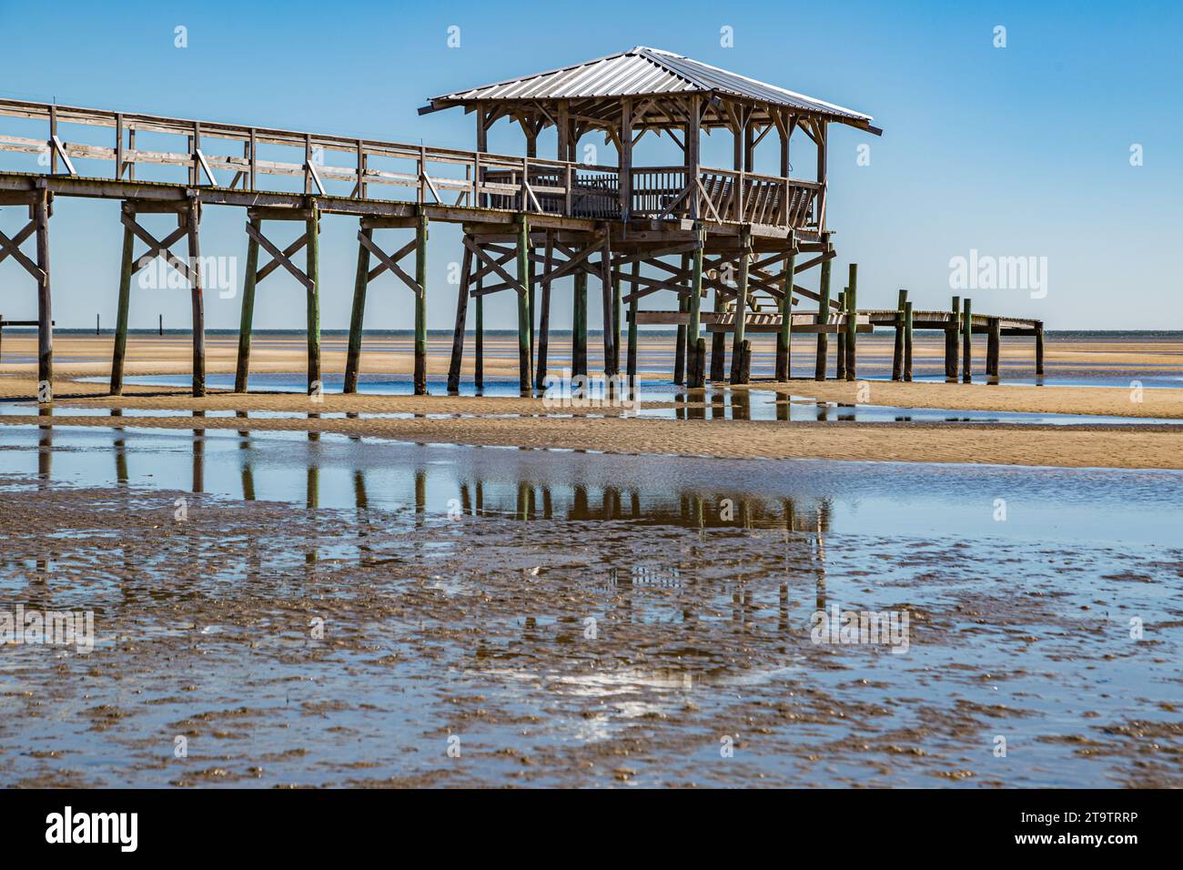 Vieux quai en bois délabré, hangar à bateaux, et jetée se dresse au-dessus des piscines de marée sur la plage de Waveland, Mississippi à marée basse. Banque D'Images