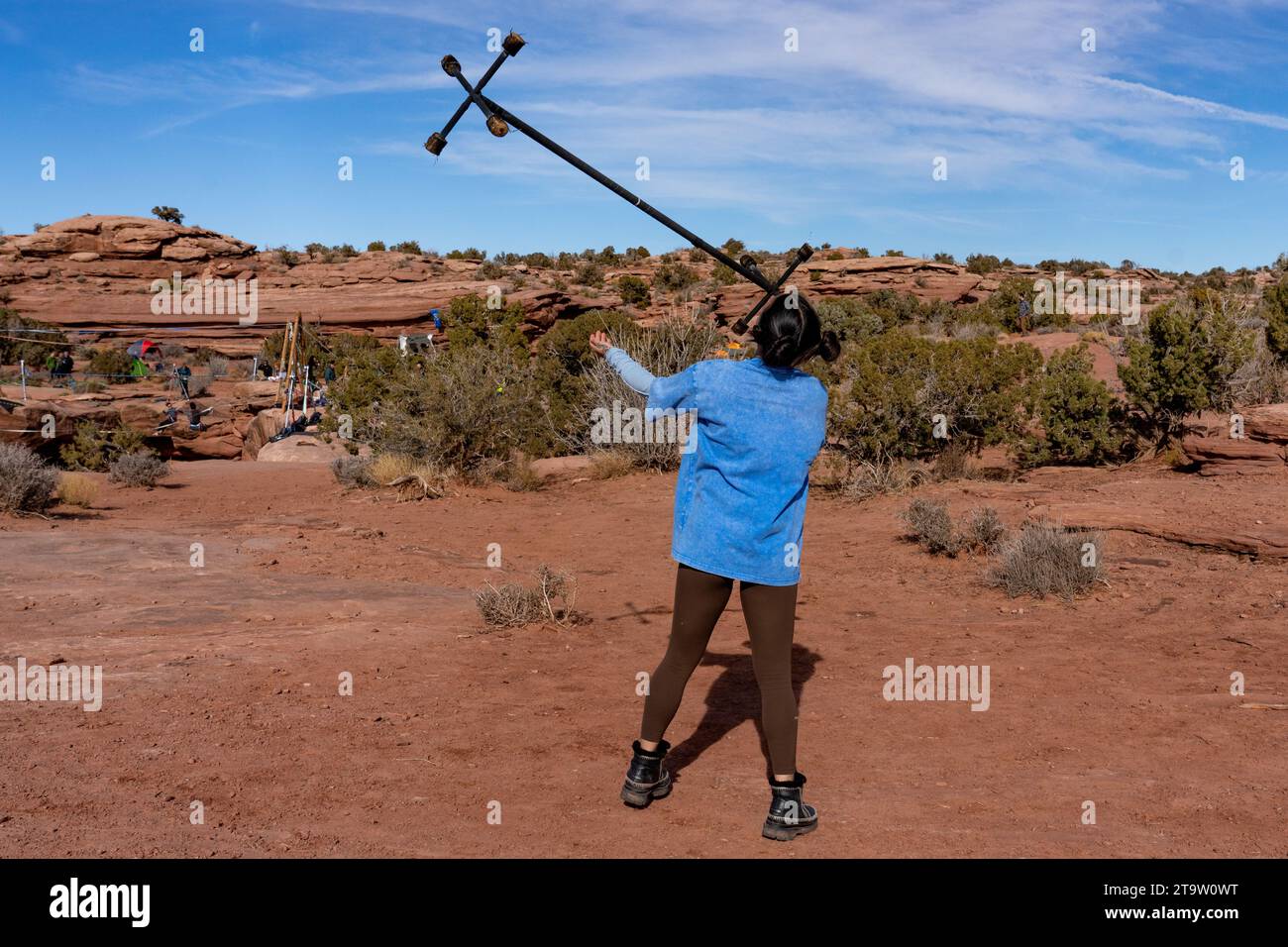 Une jeune femme s'entraîne avec un personnel de dragon de feu au GGBY Highlining Festival à Moab, Utah. Habituellement, les performances sont après la tombée de la nuit et les huit wi Banque D'Images