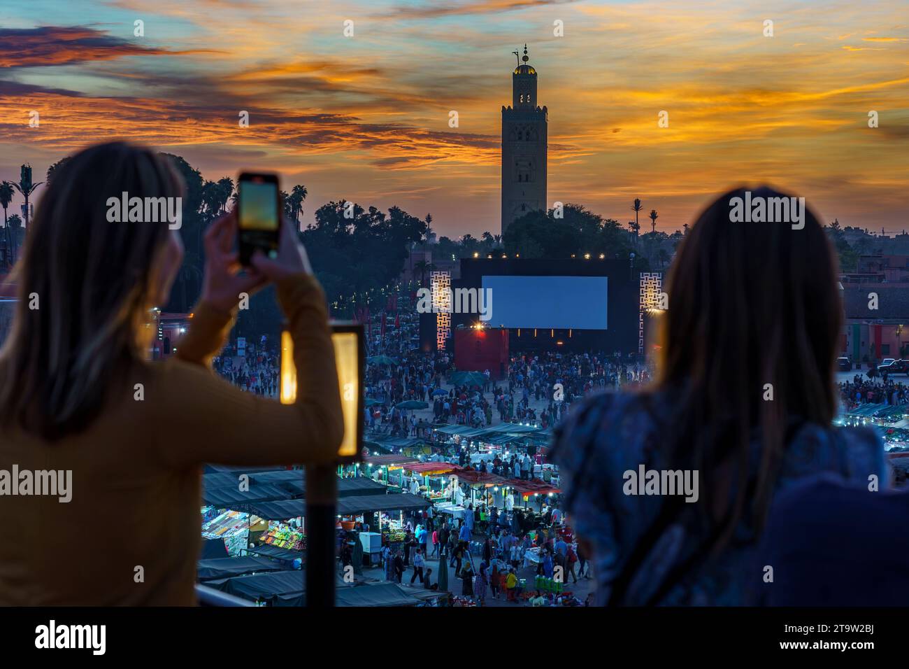 Afrique du Nord. Maroc. Marrakech. Femmes prenant des photos à la place Jemaa el fna au coucher du soleil Banque D'Images