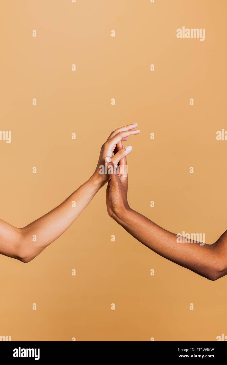 Gros plan de deux mains féminines ensemble sur fond brun. Mains de deux femmes afro-américaines. Banque D'Images