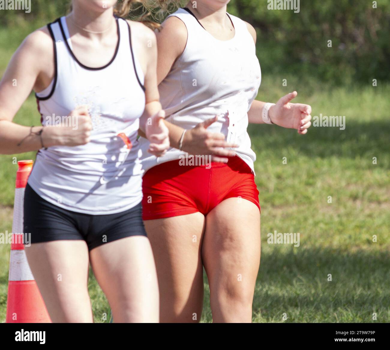 Deux femmes courent dans une course de cross-country dans l'herbe dans le parc d'État de Sunken Meadow. Banque D'Images