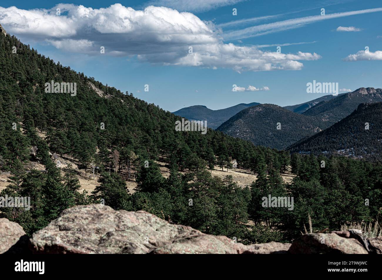 Une vue panoramique sur une chaîne de montagnes avec des arbres imposants et des rochers déchiquetés sur la colline en pente Banque D'Images