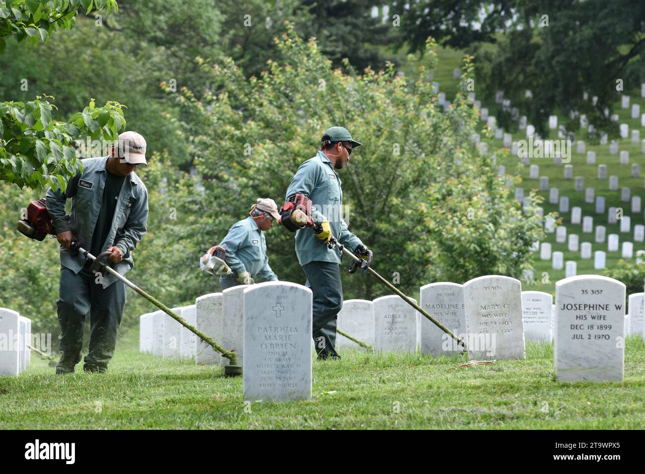 Washington, DC - 01 juin 2018 : les travailleurs tondent une herbe sur le cimetière national d'Arlington. Banque D'Images