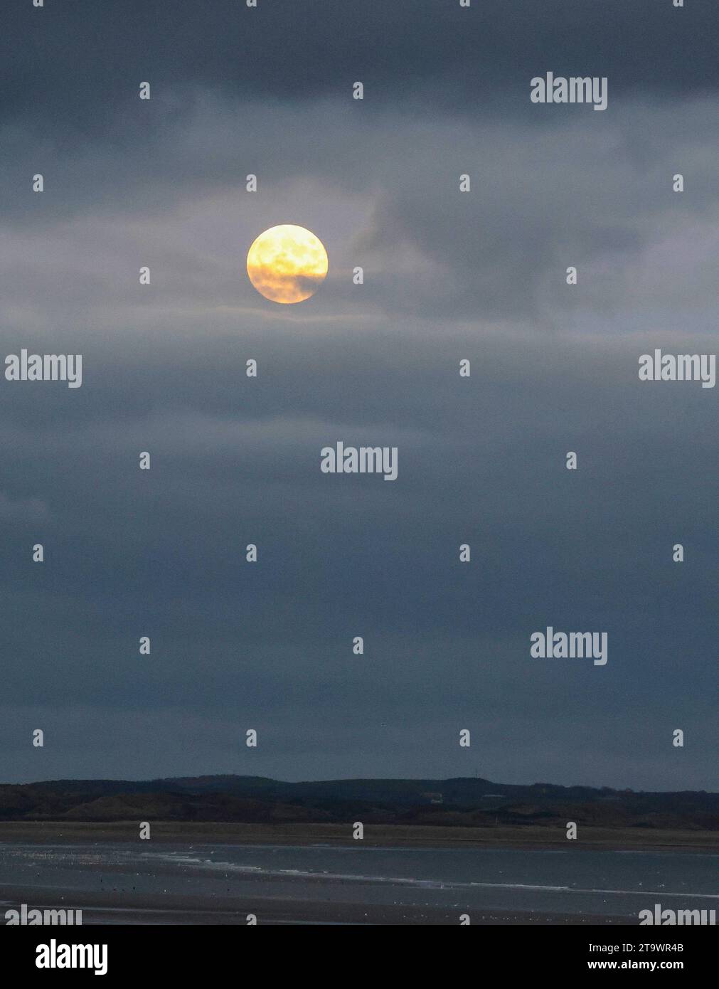Newcastle, comté de Down, Irlande du Nord, Royaume-Uni. 27 novembre 2023. Lune de novembre ou Beaver Moon visible dans un ciel dégagé au-dessus de la côte du comté de Down. La lune traverse les nuages de fin d'après-midi à 16,21 GMT. Crédit : CAZIMB/Alamy Live News. Banque D'Images