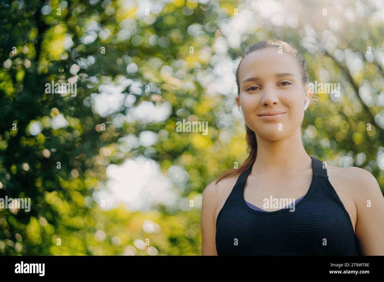 Jeune sportswoman confiant avec des écouteurs profitant de la nature Banque D'Images