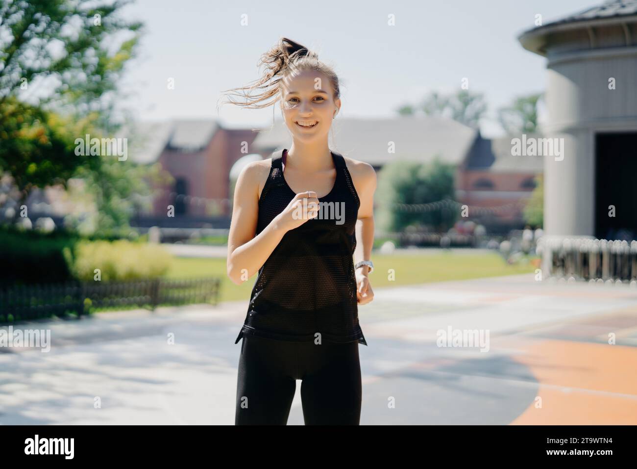 Confiante jeune femme jogging dans le parc urbain, fitness dans la ville Banque D'Images