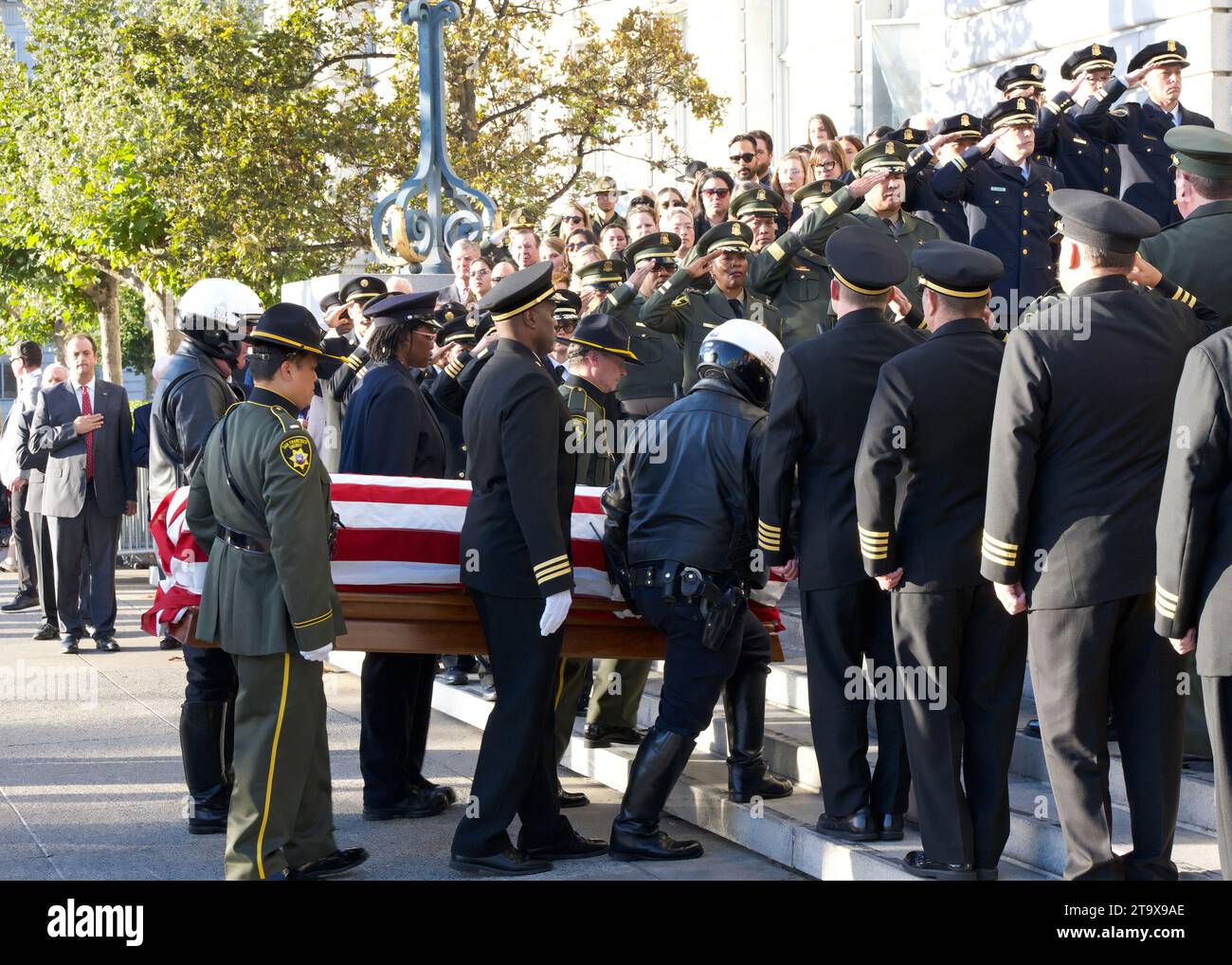 San Francisco, CA - Oct 4, 2023 : spectateurs, policiers et pompiers se tiennent à l'attention comme le cercueil avec le défunt sénateur Dianne Feinsteins corps est Banque D'Images