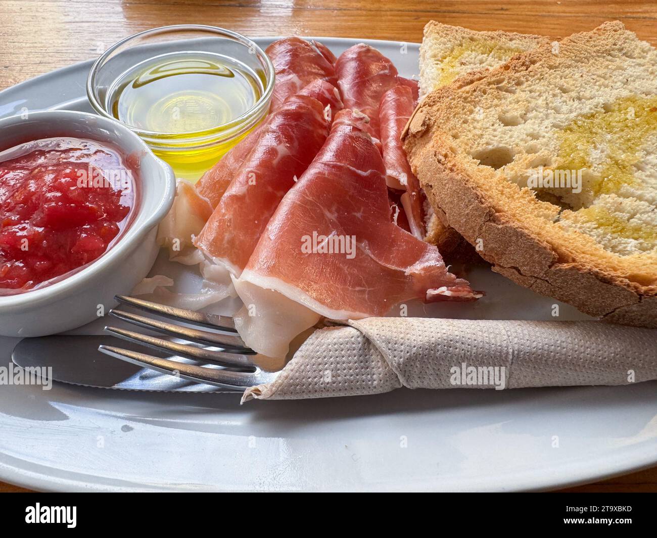 Rôti de jambon Serrano avec tomate et huile d'olive sur la table du restaurant Banque D'Images