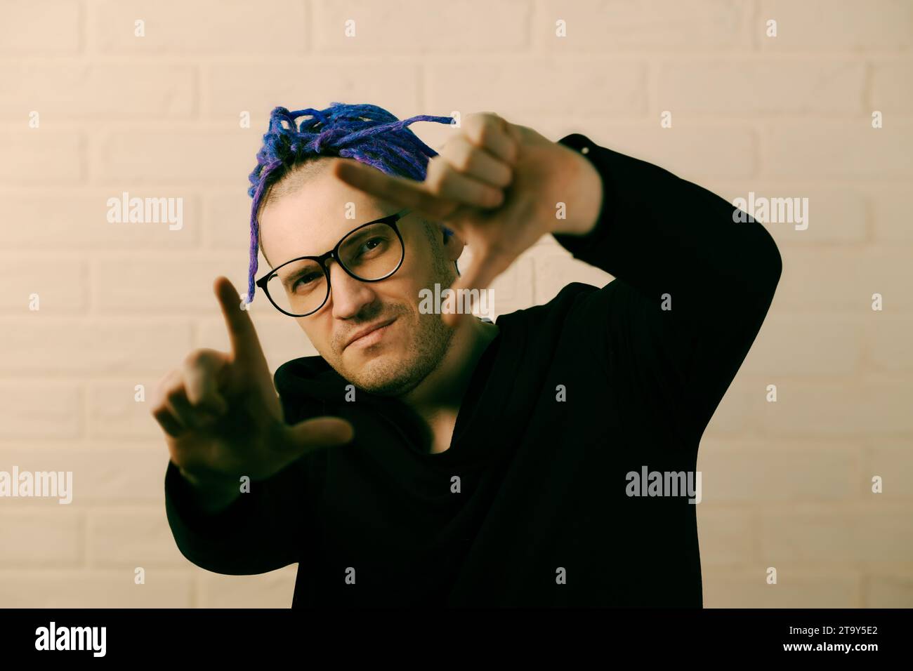 L'homme vibrant avec des dreadlocks violets frappants et un style unique. Banque D'Images
