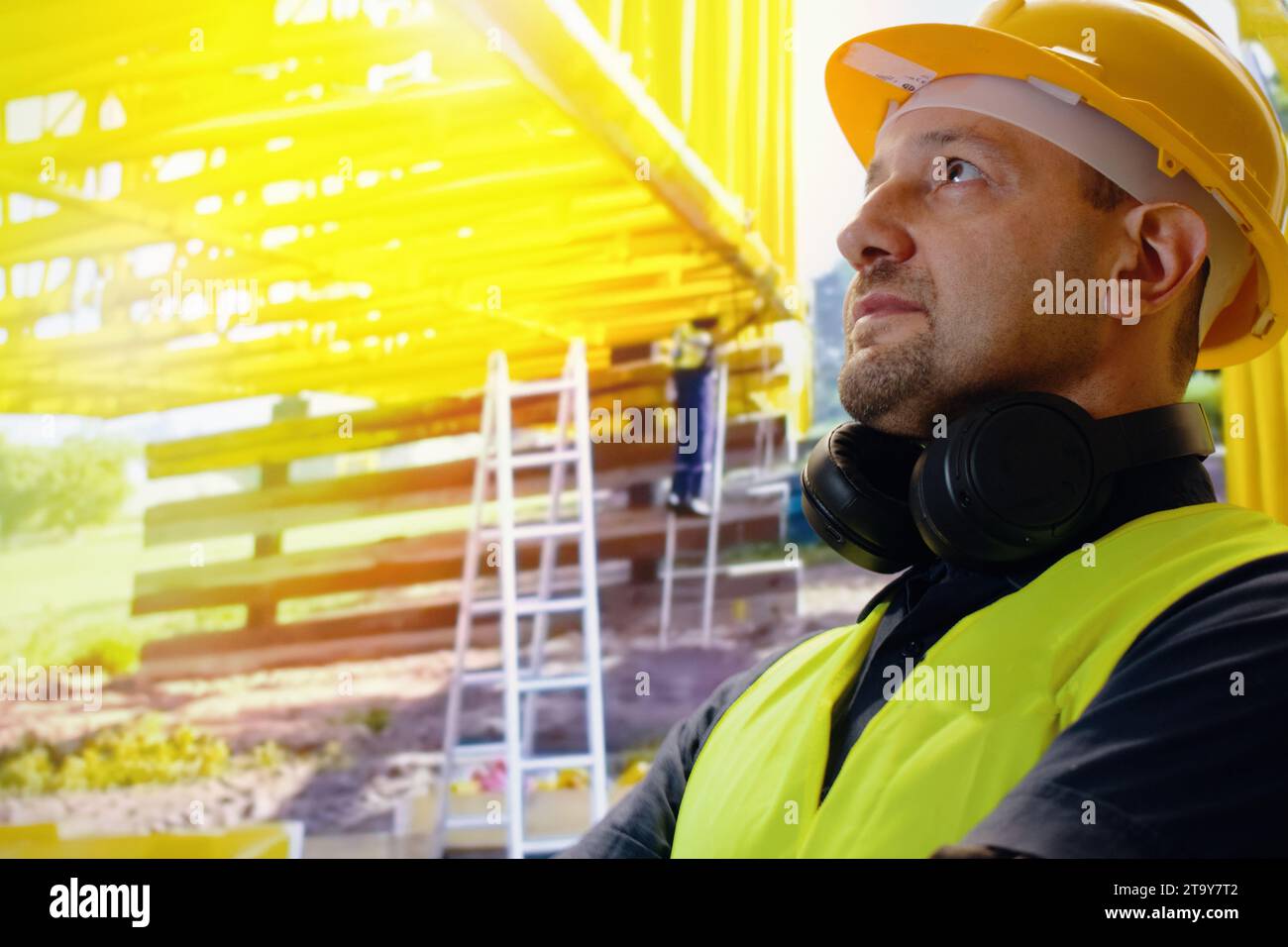 Portrait du jeune homme est un ingénieur portant un casque sourire avec satisfait sur le chantier, architecte ou entrepreneur debout et les bras croisés avec con Banque D'Images