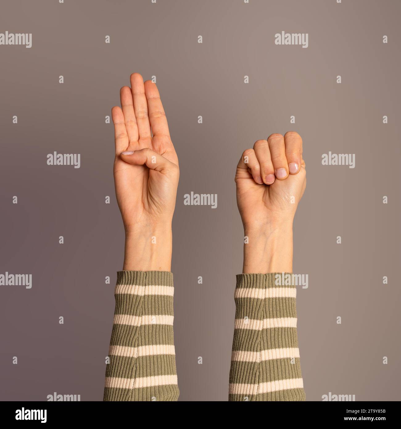 Mains levées affichant le « signal d'aide », un SOS secret utilisé pour communiquer silencieusement une détresse ou un danger. Banque D'Images