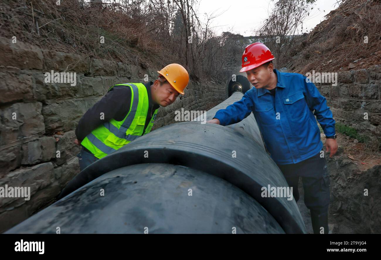 ZAOZHUANG, CHINE - 23 NOVEMBRE 2023 - les travailleurs vérifient la qualité des raccords de tuyauterie et l'avancement du chantier de construction de la canalisation d'approvisionnement en eau Banque D'Images