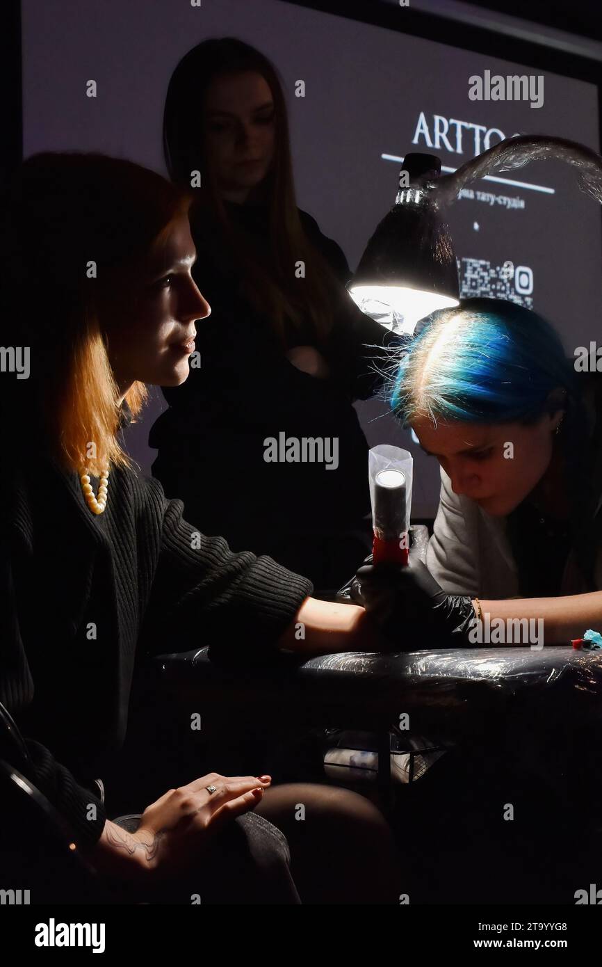 Zaporizhzhia, Ukraine. 25 novembre 2023. Un tatoueur vu travailler sur un client pendant le festival de tatouage caritatif «Walk-In Day» à Zaporizhzhia. Le festival de tatouage caritatif 'Walk-In Day' a eu lieu dans la plate-forme créative 'Mlinn' à Zaporizhzhia. Le but du Festival est de collecter des dons pour l'école de drones militaires Zaporizhzhia. L'espace de bataille ukrainien présente l'utilisation la plus intensive de drones dans un conflit militaire de l'histoire, marquant un changement dans les tactiques et la technologie de guerre. (Photo Andriy Andriyenko/SOPA Images/Sipa USA) crédit : SIPA USA/Alamy Live News Banque D'Images