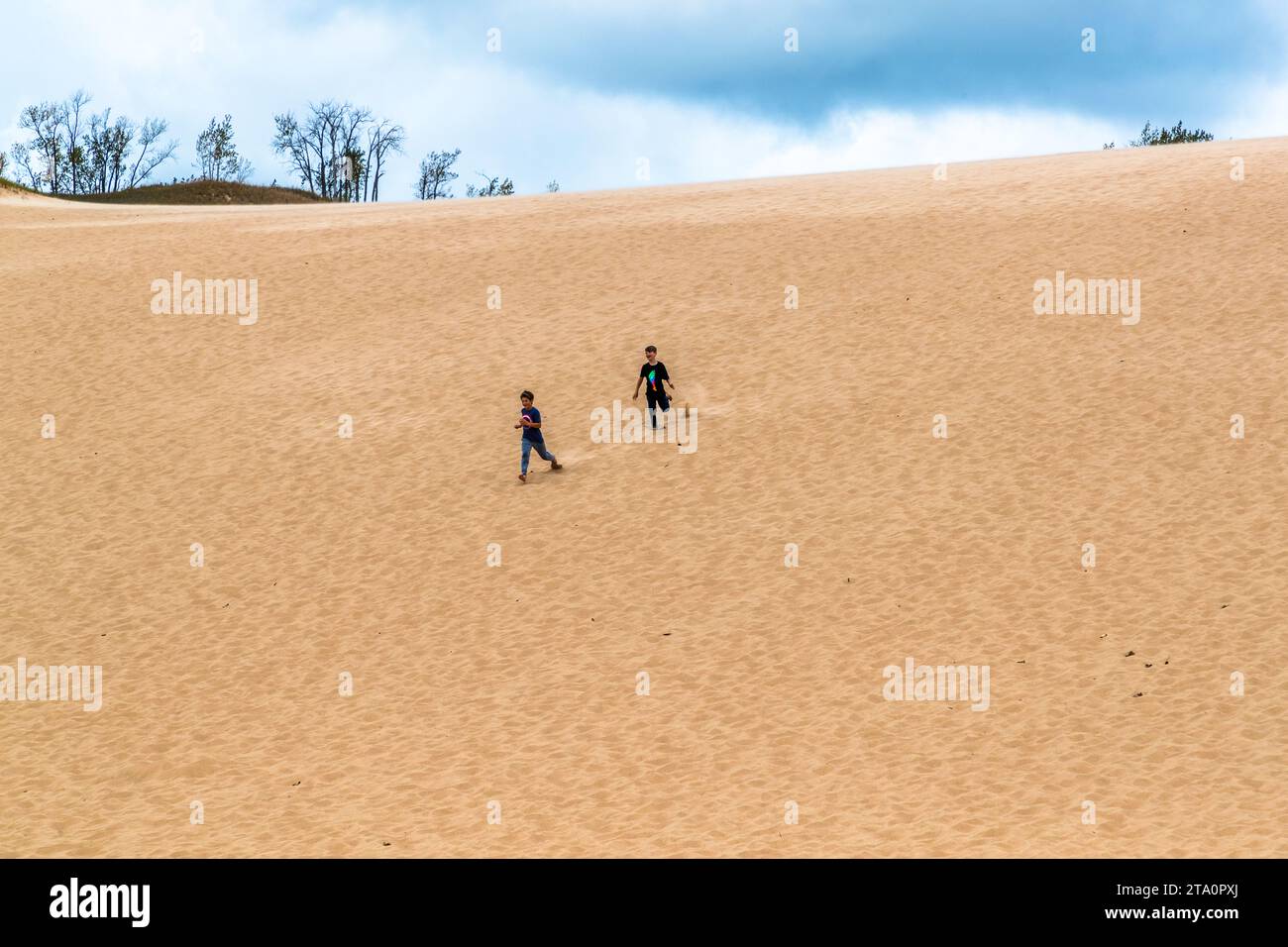 Enfants courant sur une dune de sable dans le parc national Sleeping Bear, Michigan. Sleeping Bear Dunes National Lakeshore. Glen Arbor Township, États-Unis Banque D'Images