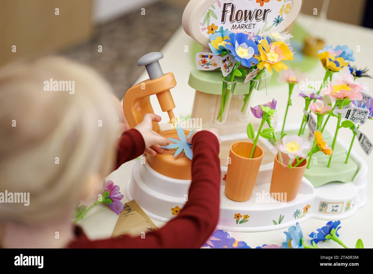 28 novembre 2023, Bavière, Nuremberg : Franziska, 5 ans, joue avec le «marché aux fleurs» de Smoby Toys lors de la conférence de presse annuelle de l'Association allemande de vente au détail de jouets (BVS) et de l'Association allemande de l'industrie du jouet (DVSI). Le jouet, qui permet aux enfants de créer leurs propres fleurs, est l'un des 'Top 10 Toys 2023' publié par le BVS. Le DVSI et le BVS donnent un aperçu des importantes affaires de Noël et des chiffres actuels pour les derniers mois. Photo : Daniel Karmann/dpa Banque D'Images