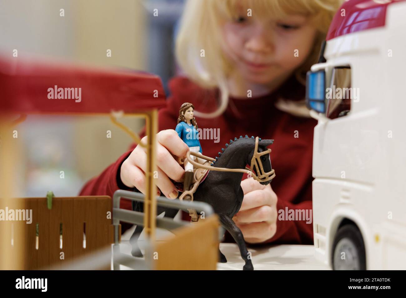 Nuremberg, Allemagne. 28 novembre 2023. Franziska, 5 ans, joue avec le « Horse Club Horse transporter » du fabricant de jouets Schleich en marge de la conférence de presse annuelle de l'Association allemande de vente au détail de jouets (BVS) et de l'Association allemande de l'industrie du jouet (DVSI). Le jouet est l'un des 'Top 10 Toys 2023' liste publiée par le BVS. Le DVSI et le BVS donnent un aperçu des importantes affaires de Noël et des chiffres actuels pour les derniers mois. Crédit : Daniel Karmann/dpa/Alamy Live News Banque D'Images