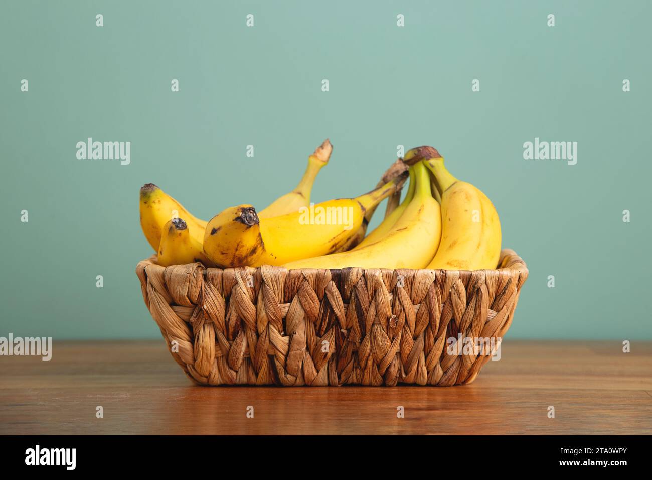 Bananes dans le panier en osier à la maison. Banque D'Images