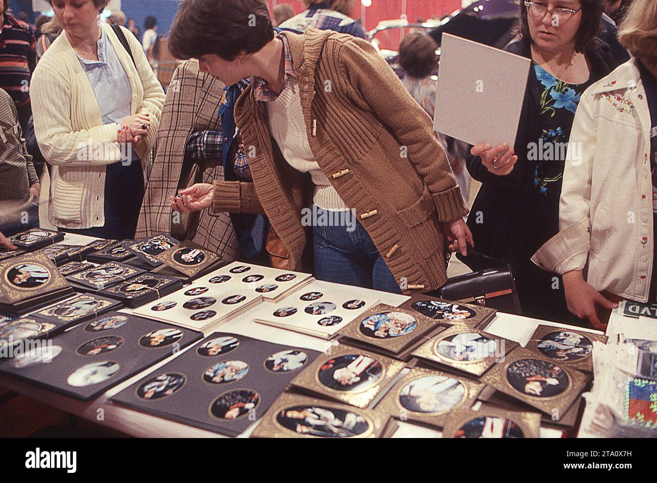 Lors d'un spectacle de souvenirs d'Elvis en 1978, en conjonction avec son 1e anniversaire après son décès, les femmes parcourent les photos d'Elivs à vendre. À Memphis, Tennessee. Banque D'Images