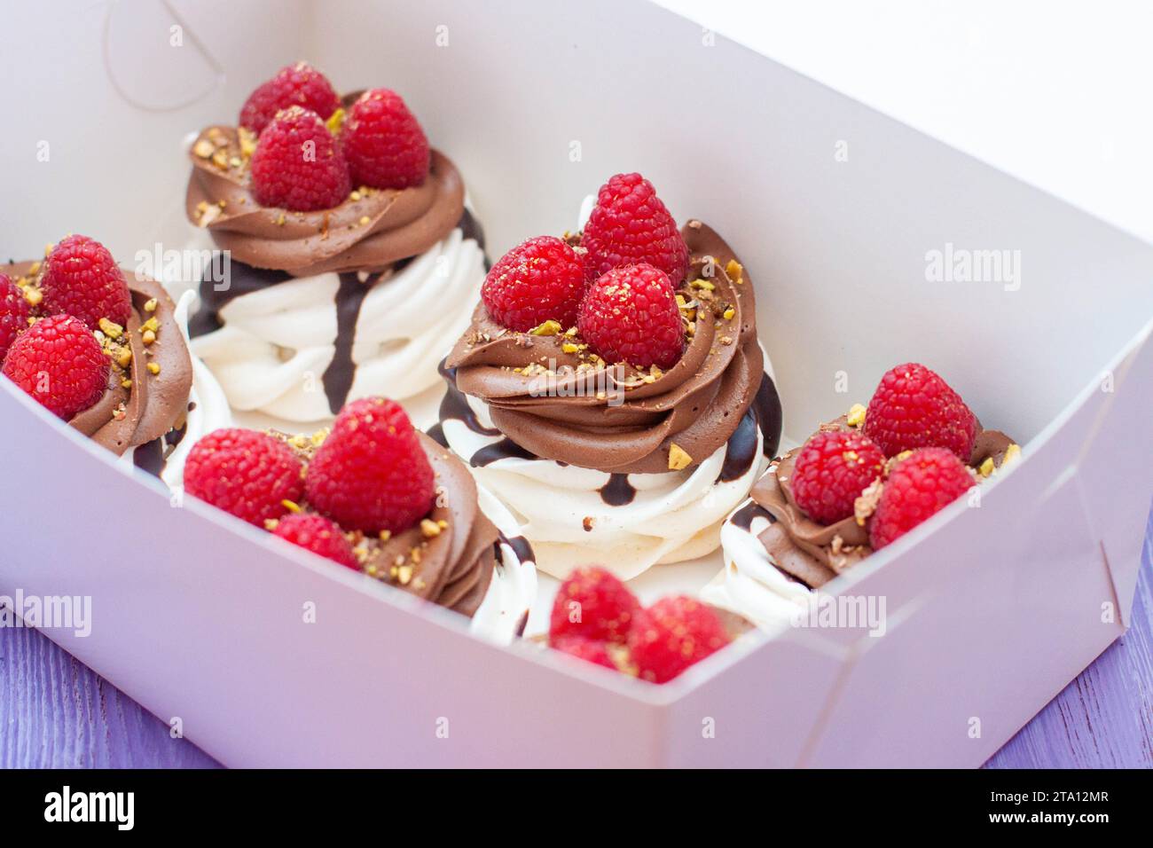 Mini gâteaux à la crème fouettée, chocolat, meringue et framboises fraîches. Affiche de confiserie pour café ou restaurant Banque D'Images