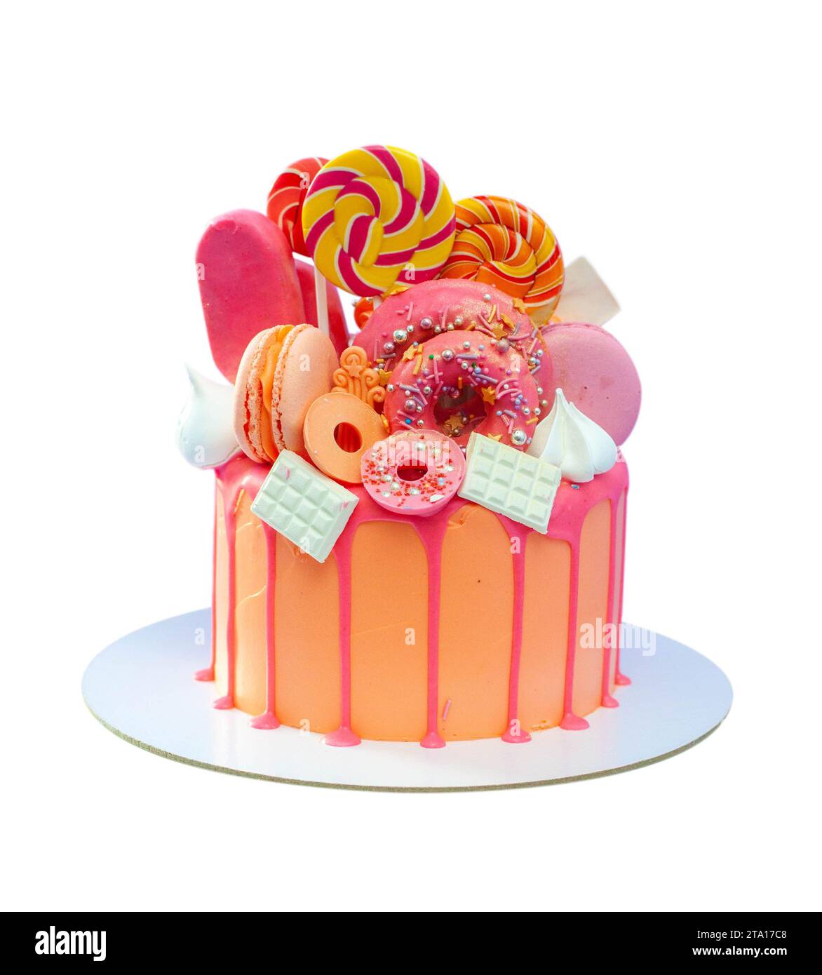 Gâteau rose décoré de sucettes colorées, beignets, popsicles, tourbillons de meringue, barres de chocolat et étoiles dorées. Isolé sur fond blanc Banque D'Images