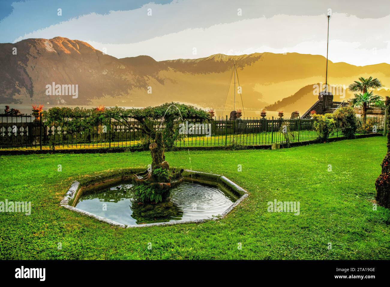 Herbe verte , fontaine dans le parc sur la rive du lac de Côme , (un petit morceau d'eau) et Alpes italiennes de l'autre côté. Court voyage fantastique pendant CHRI Banque D'Images
