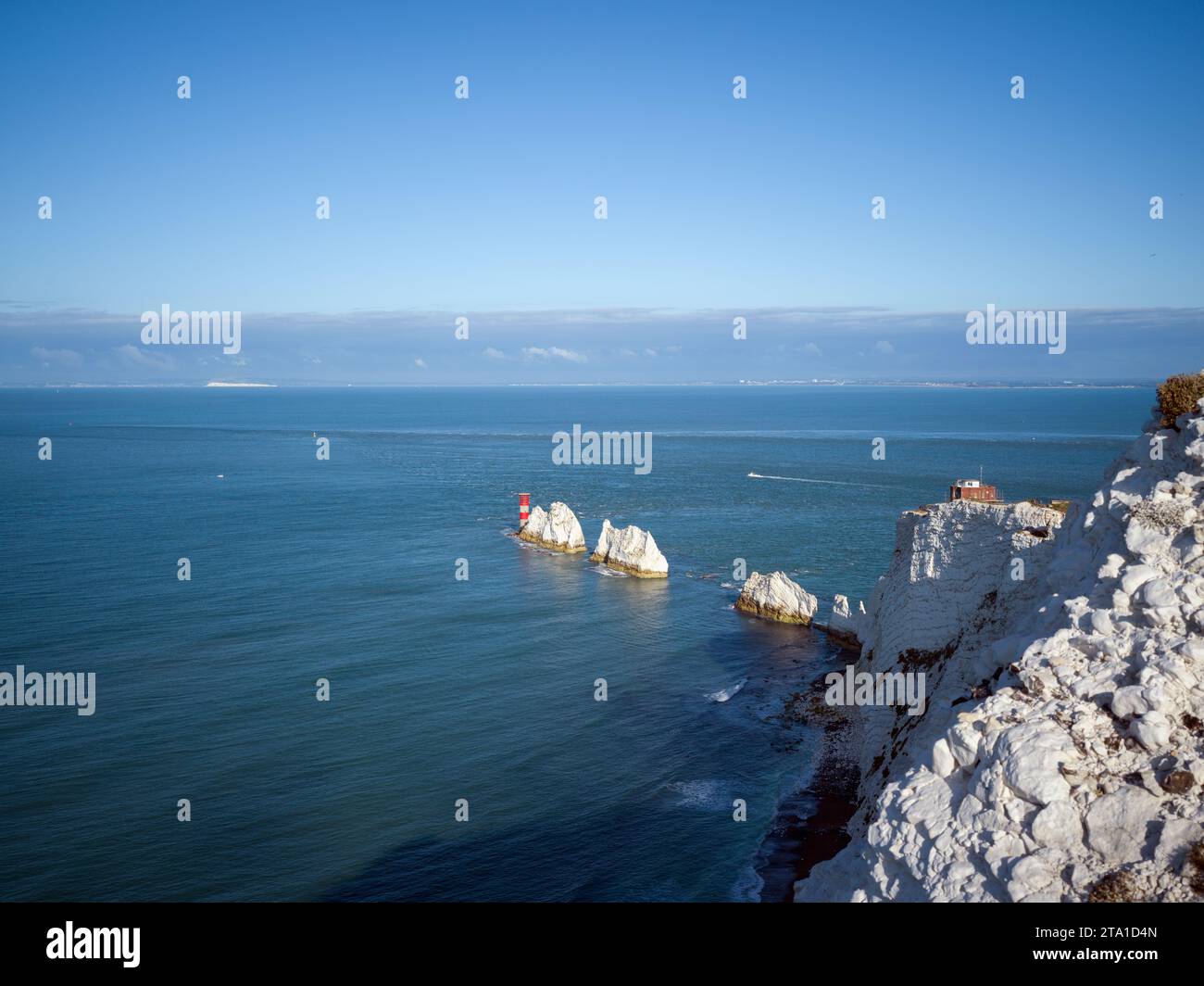 Le phare des aiguilles et les piles de craie vus de High Down, île de Wight dans la lumière du matin. La côte du Dorset est visible au loin Banque D'Images