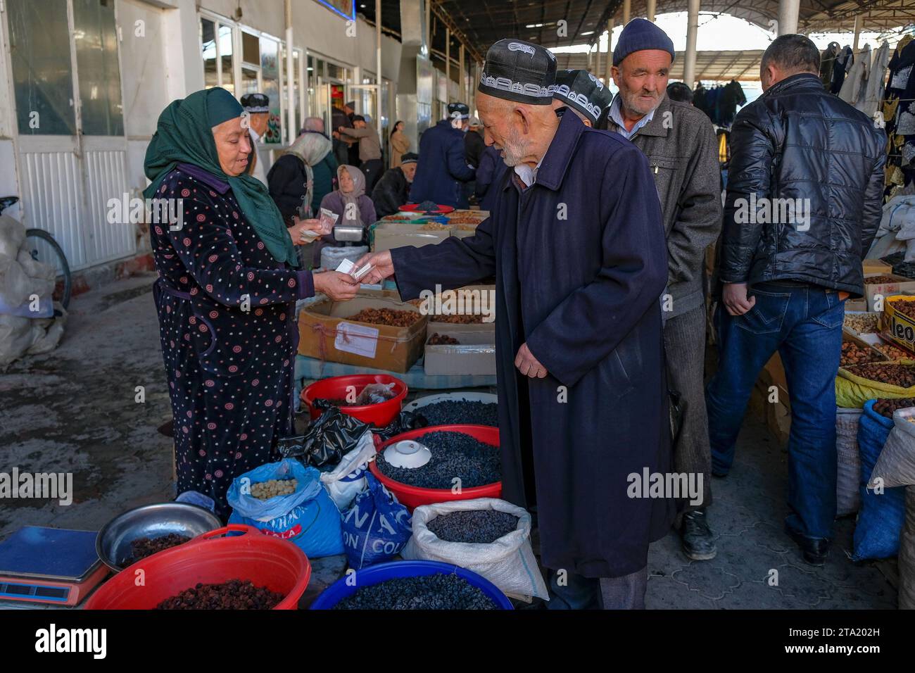 Istaravshan, Tadjikistan - 26 novembre 2023 : les gens achètent des raisins secs et des fruits secs au marché central d'Istaravshan, Tadjikistan. Banque D'Images