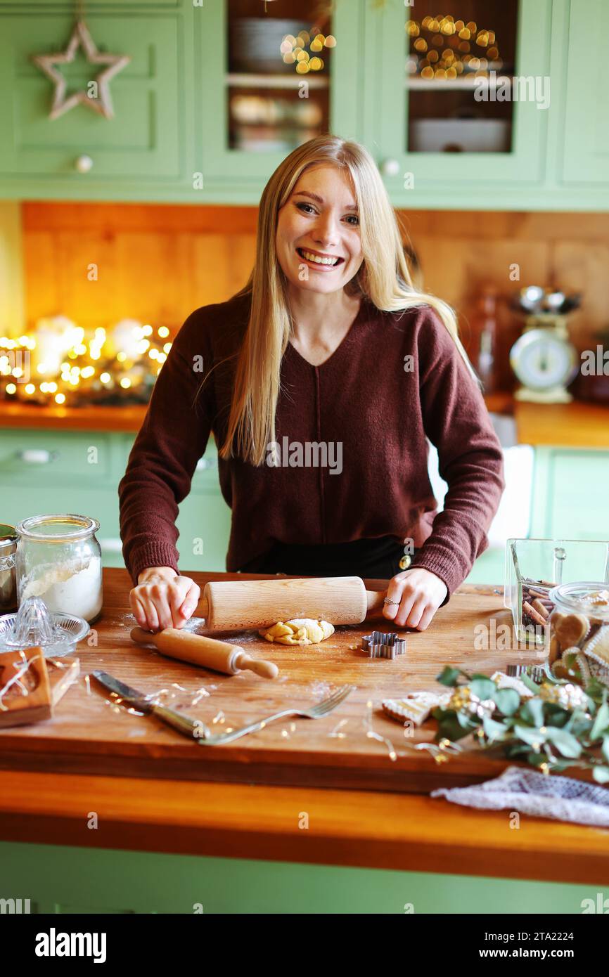 Les femmes étalent la pâte pour les biscuits de Noël Banque D'Images