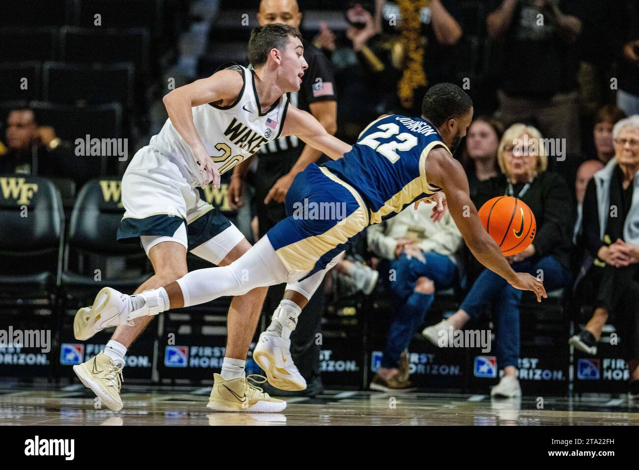 Winston-Salem, Caroline du Nord, États-Unis. 24 novembre 2023. Wake Forest Demon Deacons garde Parker Friedrichsen (20) et Charleston Southern Buccaneers RJ Johnson (22) après un ballon lâche pendant la première moitié du match de basket-ball de la NCAA au LJVM Coliseum à Winston-Salem, Caroline du Nord. (Scott Kinser/Cal Sport Media). Crédit : csm/Alamy Live News Banque D'Images