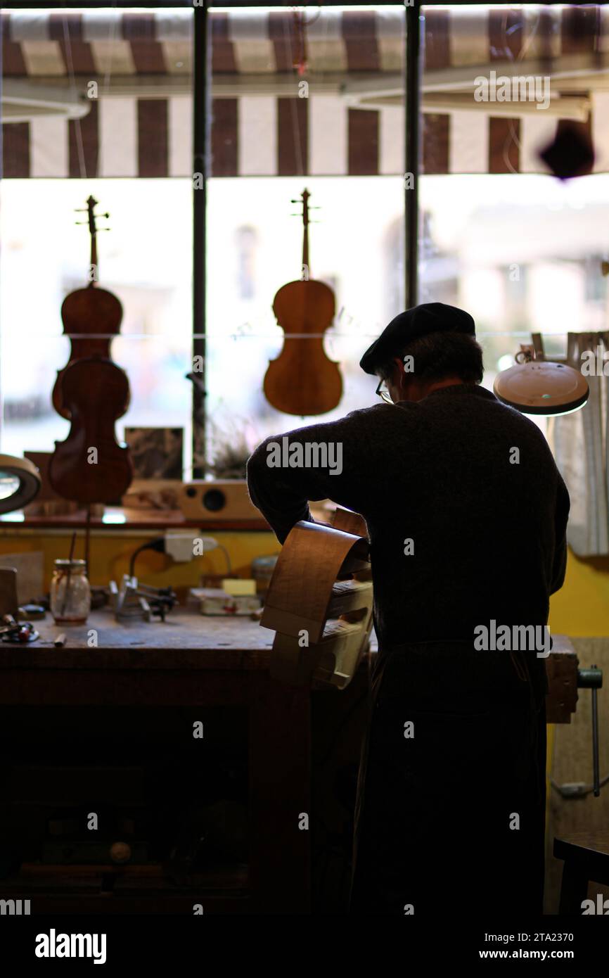 Expert senior luthier artisan violoniste sculpter les côtes ciselées d'un nouveau modèle classique violoncelle dans l'atelier Crémone Italie Banque D'Images