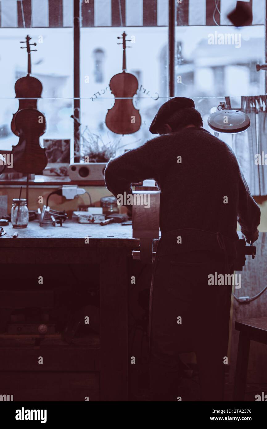Expert senior luthier artisan violoniste sculpter les côtes ciselées d'un nouveau modèle classique violoncelle dans l'atelier Crémone Italie Banque D'Images