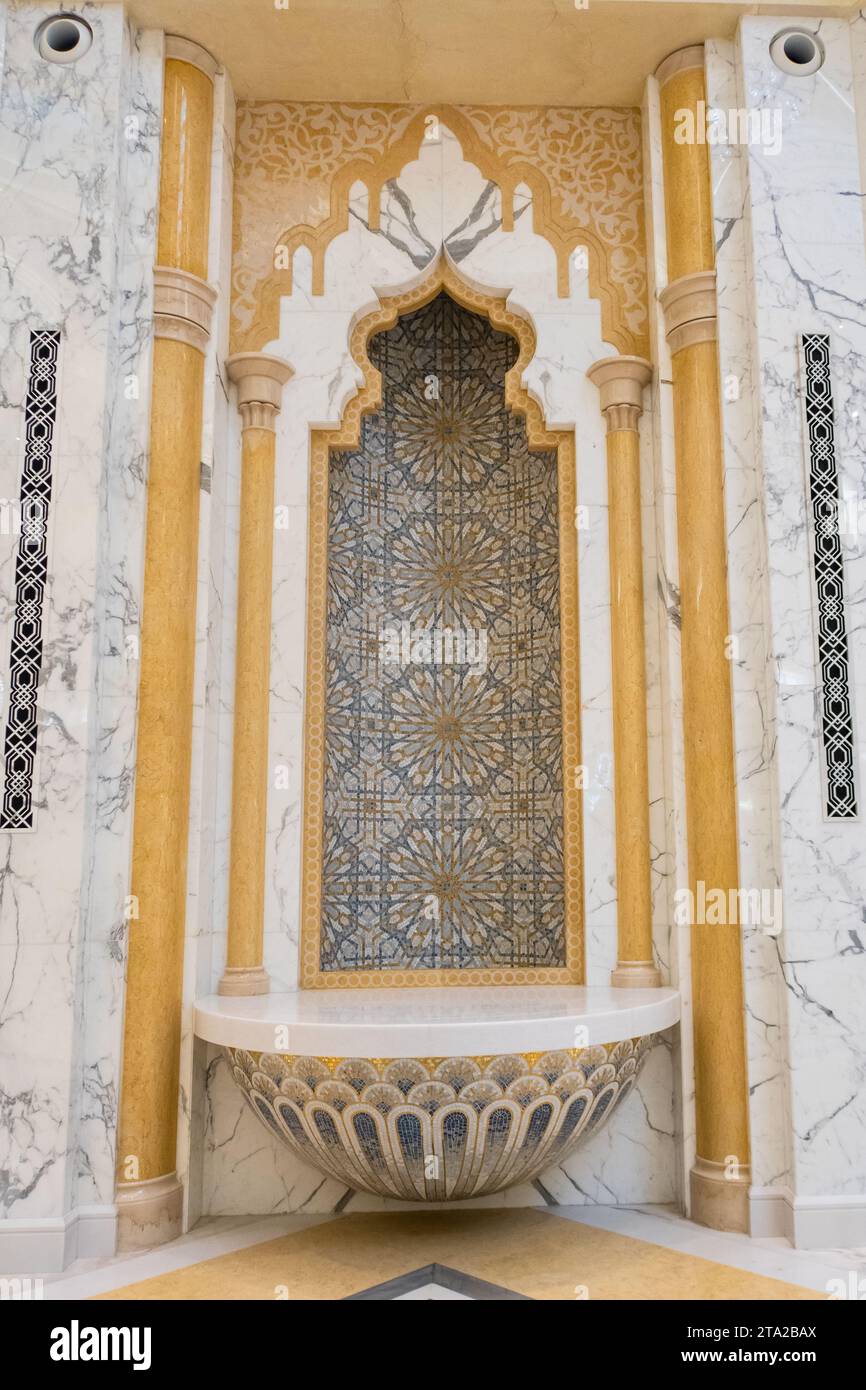 Abu Dhabi, eau, 08.02.20. Niche en granit et marbre de style arabe (mihrab), avec mosaïques dorées, motifs géométriques étoilés et floraux et colonnes dorées Banque D'Images