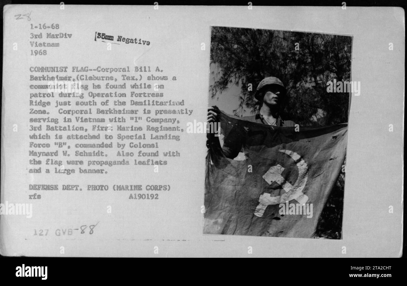 Le caporal Bill A. Berkheimer de la compagnie C, 3e bataillon, 1er régiment de Marines détient un drapeau communiste capturé et de la propagande pendant une patrouille au Vietnam le 16 janvier 1968, au sud de la zone démilitarisée. Banque D'Images