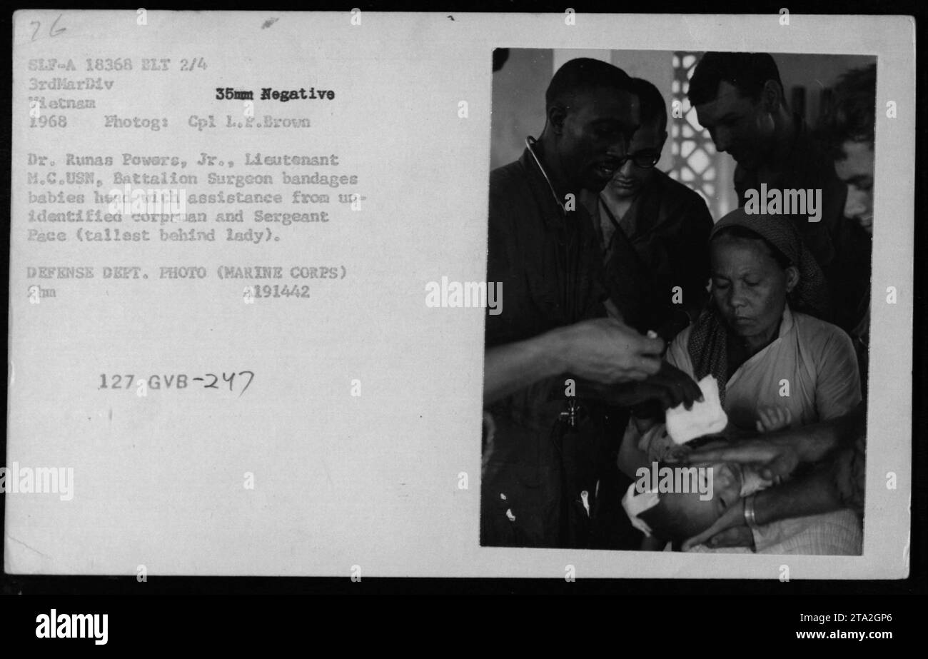 Chirurgien de bataillon, le lieutenant Dr Runas Powers, Jr, avec un cadavre non identifié et le sergent Pace, bandent la tête d'un bébé lors d'un programme d'action civile médicale (MEDCAP) au Vietnam en 1968. Cette image a été prise par le Cpl L.P. Brown et est un négatif de 35 mm provenant des archives photographiques du Département de la Défense. Banque D'Images